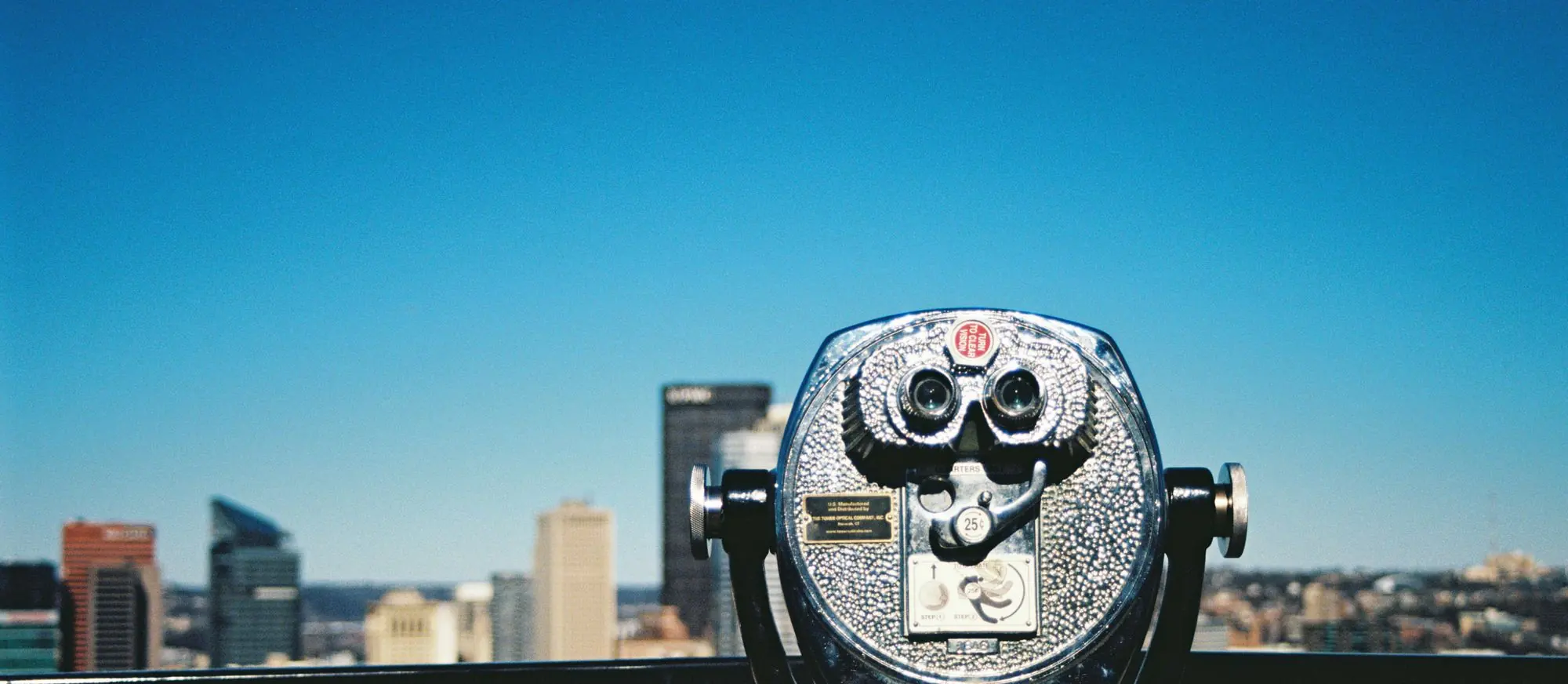A coin-operated viewer on the Mt. Washington overlook, aimed at downtown Pittsburgh under a deep blue sky